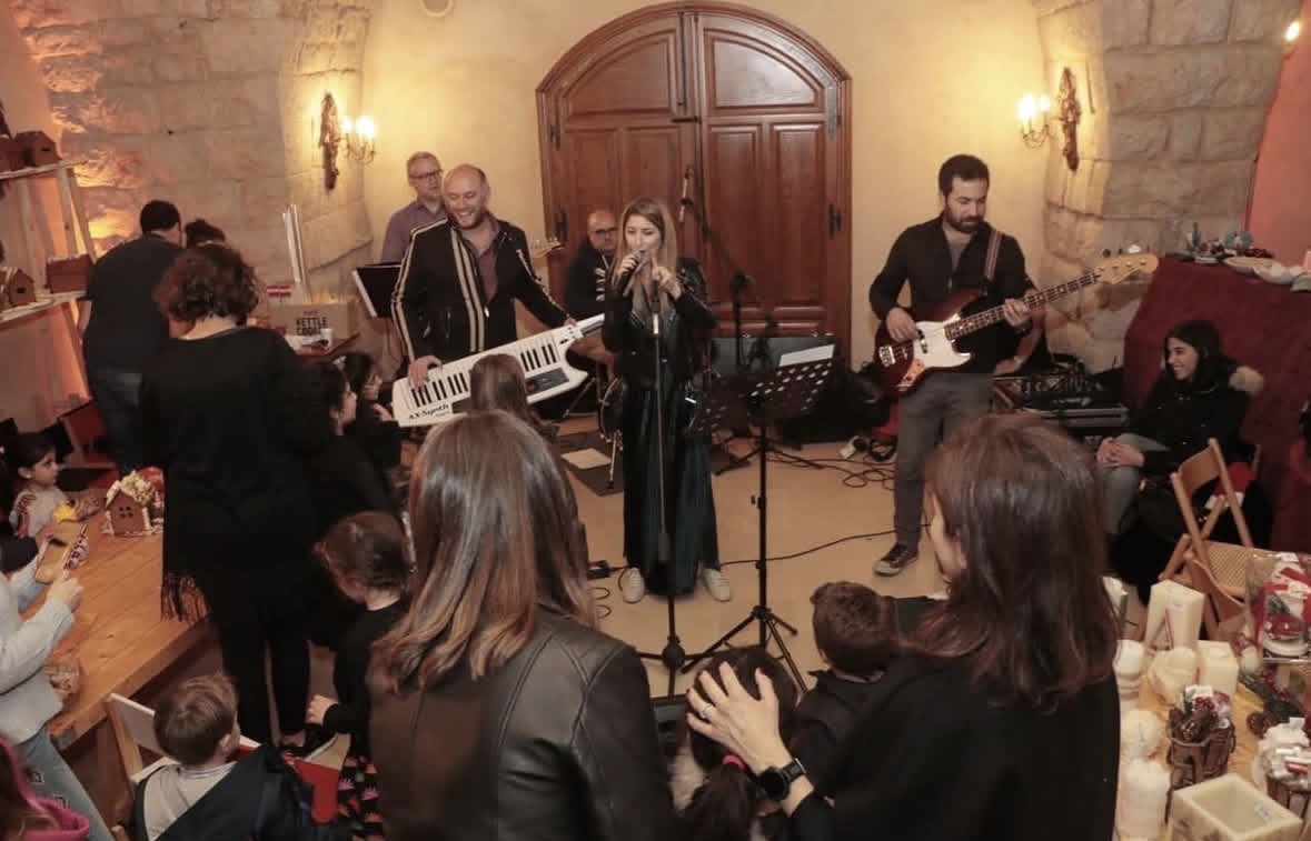 A live band plays to families beside gingerbread crafts and candles