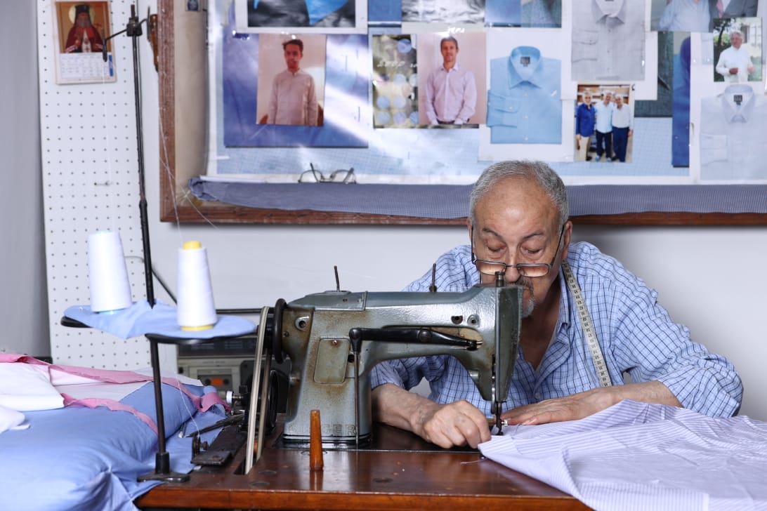 A tailor sewing a garment at Fadlo Tailoring workshop