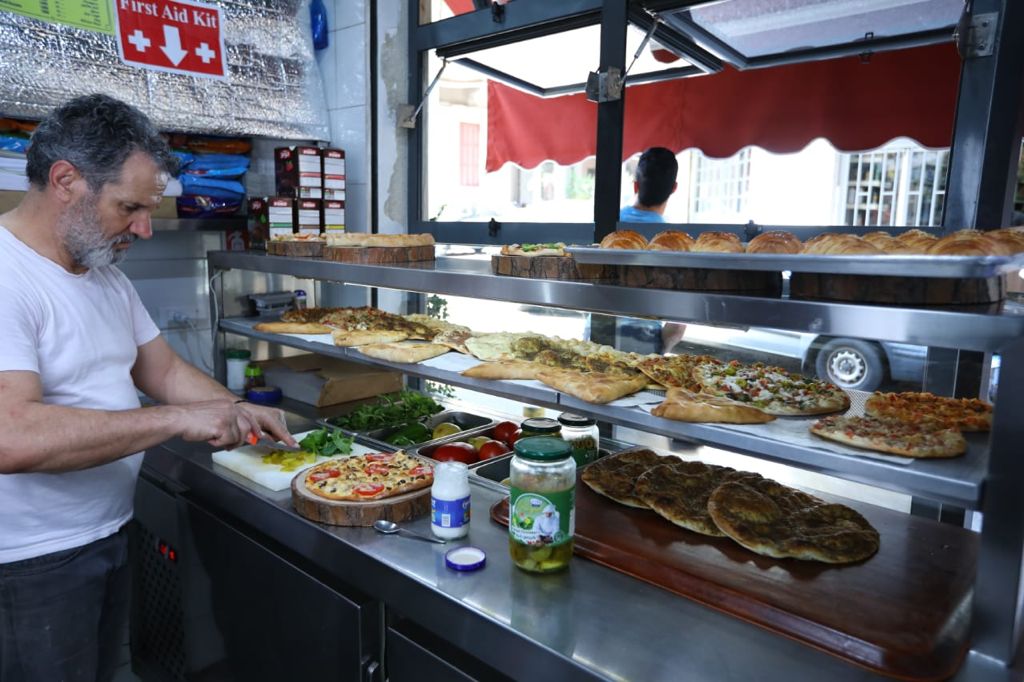 A man preparing manakish at Ajinet Salma